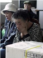 Elderly women look tired after eruptions of Mt. Usu